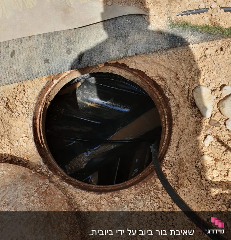 פתח ביוב עם צינור יניקה של משאית ואקום
